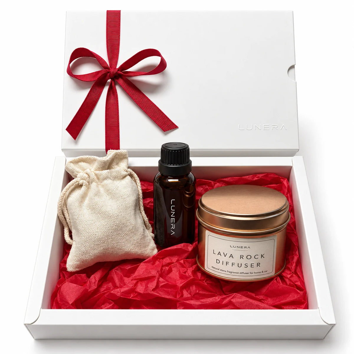 Set cadou de Crăciun Lunera cu Lava Rock Diffuser, recipient metalic cupru, ulei parfumat, săculeț din bumbac și cutie albă cu panglică roșie.