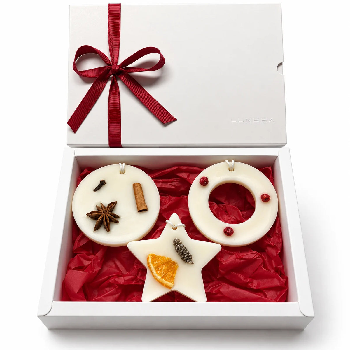 Set cadou de Crăciun Lunera Noël Enchanté cu 3 odorizante din ceară de soia, în cutie albă premium cu hârtie de mătase roșie.