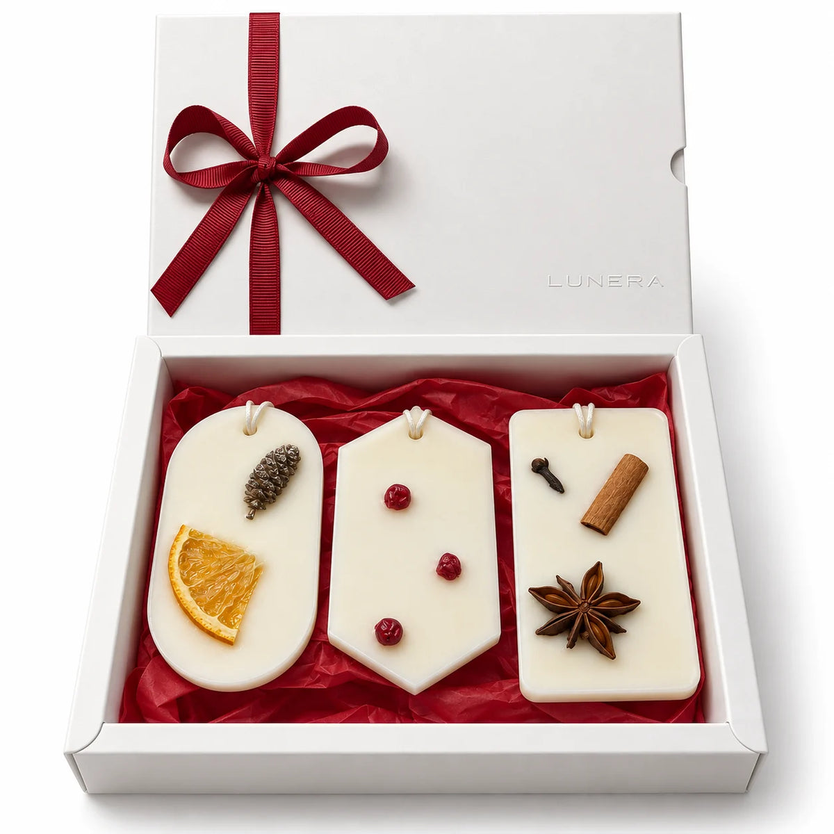 Set cadou de Crăciun Lunera Noël Signature cu 3 odorizante din ceară de soia, în cutie albă premium cu hârtie de mătase roșie.